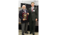 Ed Johann (left), U.S. BoilerÃ¢â¬â¢s chief engineer of product development, receives an Award of Excellence .